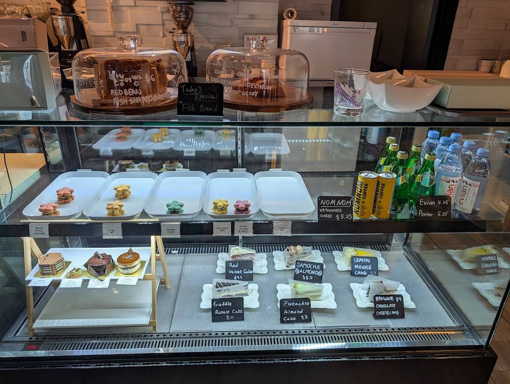 Cafe Inside display case with cakes, macarons, and pastries